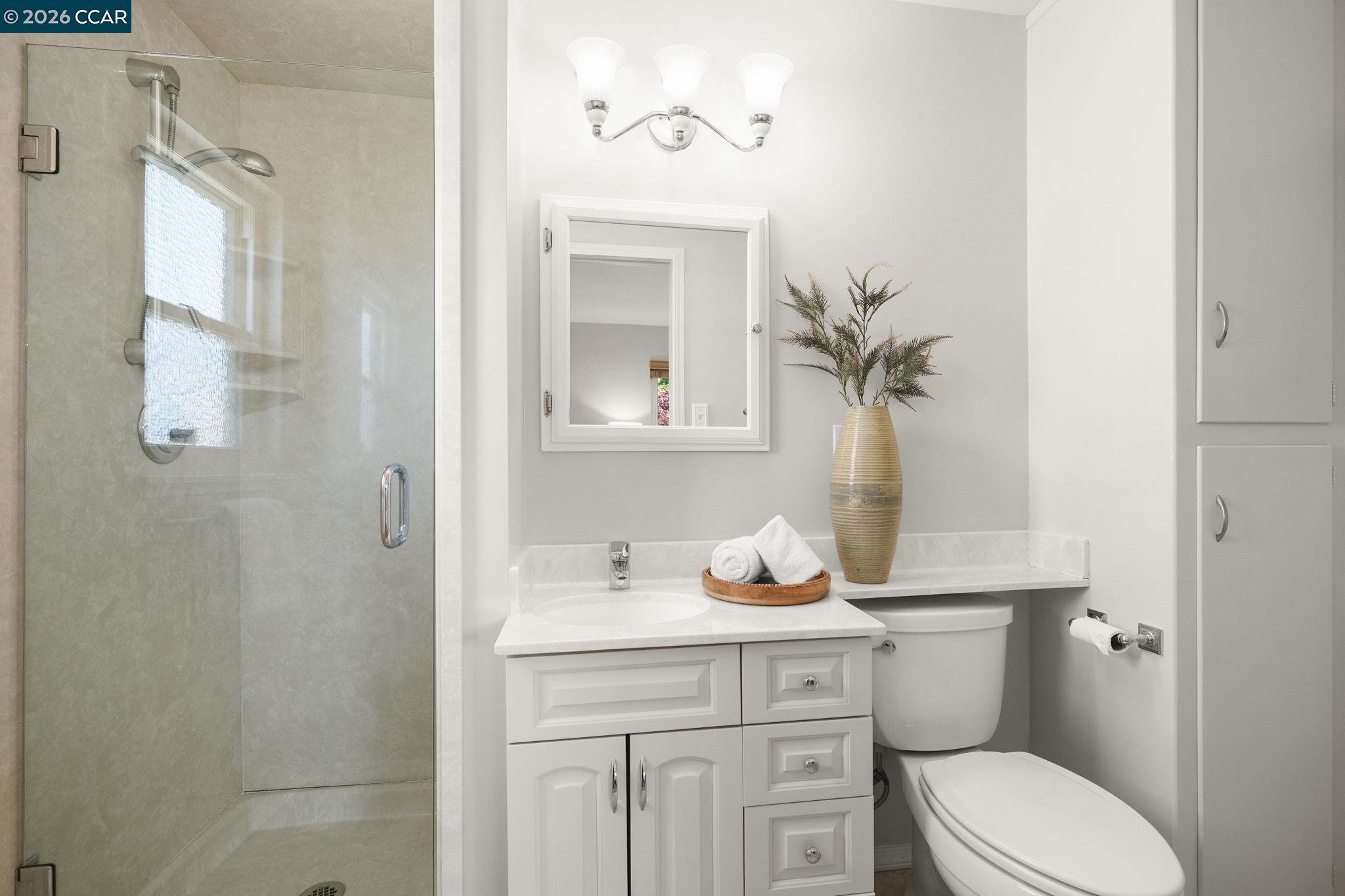 4311 Cowell Road Concord, CA 94521 - Photo 22 of 29 a bathroom with a toilet a sink and mirror