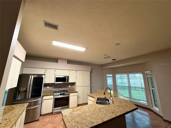 a kitchen with granite countertop a stove and a sink