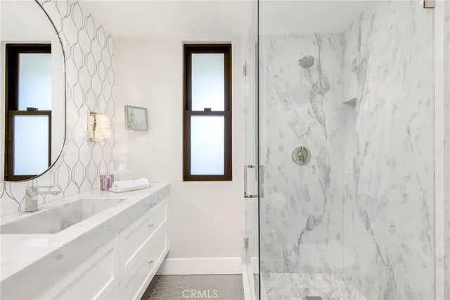 a bathroom with a granite countertop shower sink and mirror