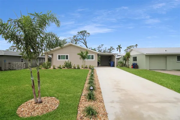 a front view of a house with a garden and yard