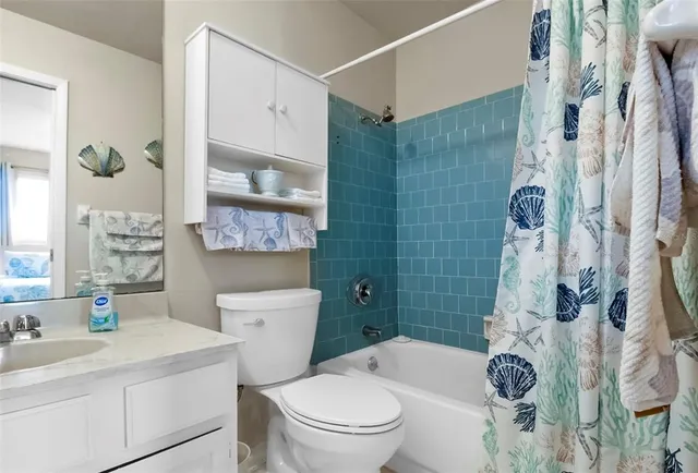 a bathroom with a sink a toilet and a shower curtain