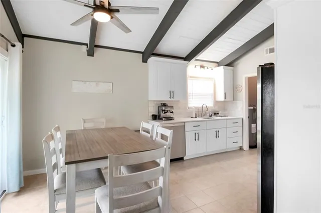 a kitchen with a table chairs refrigerator and cabinets