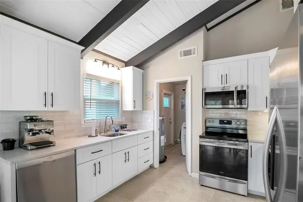 a kitchen with stainless steel appliances a stove a sink and a refrigerator
