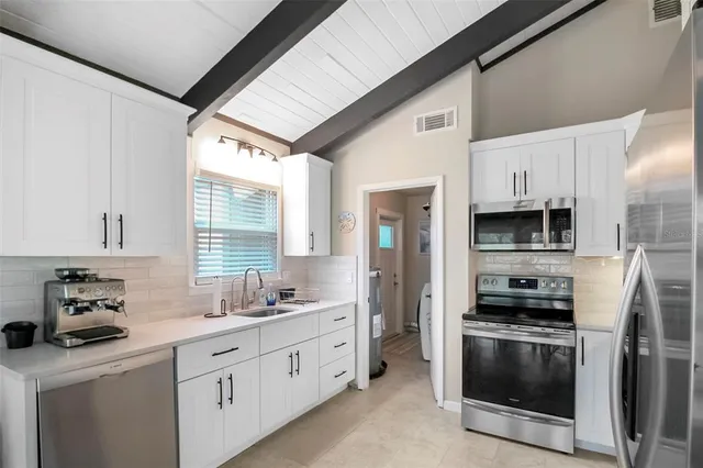 a kitchen with stainless steel appliances a stove a sink and a refrigerator