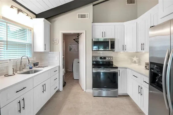 a kitchen with a sink cabinets and window