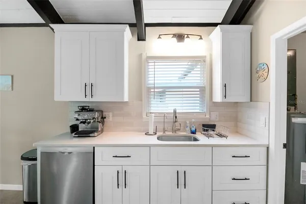 a kitchen with stainless steel appliances sink cabinets and wooden floor