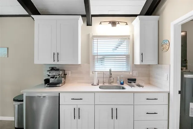 a kitchen with stainless steel appliances sink cabinets and wooden floor