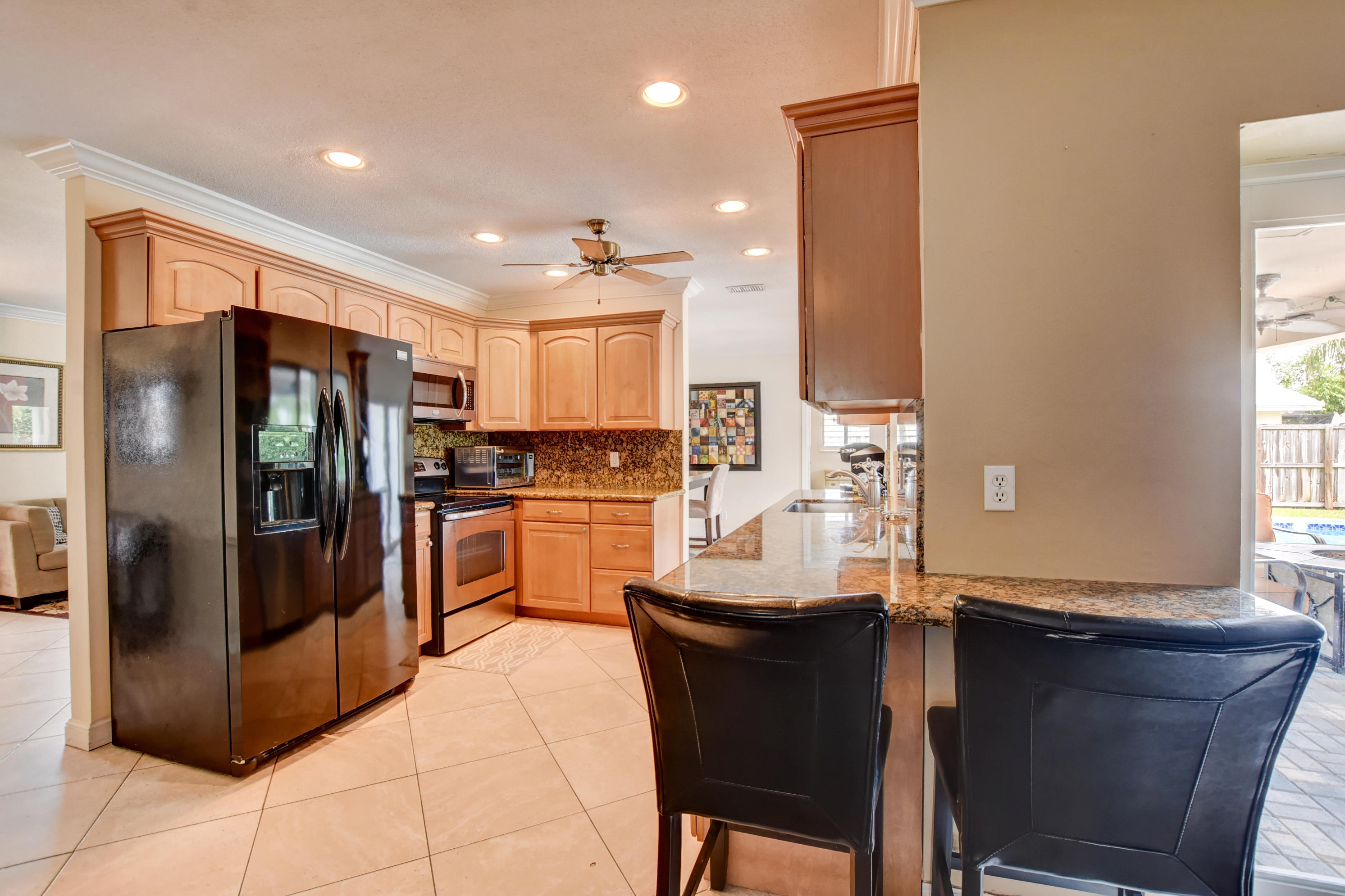 1366 Southwest 13th Place Boca Raton, FL 33486 - Photo 12 of 35 a kitchen with granite countertop a refrigerator and a sink