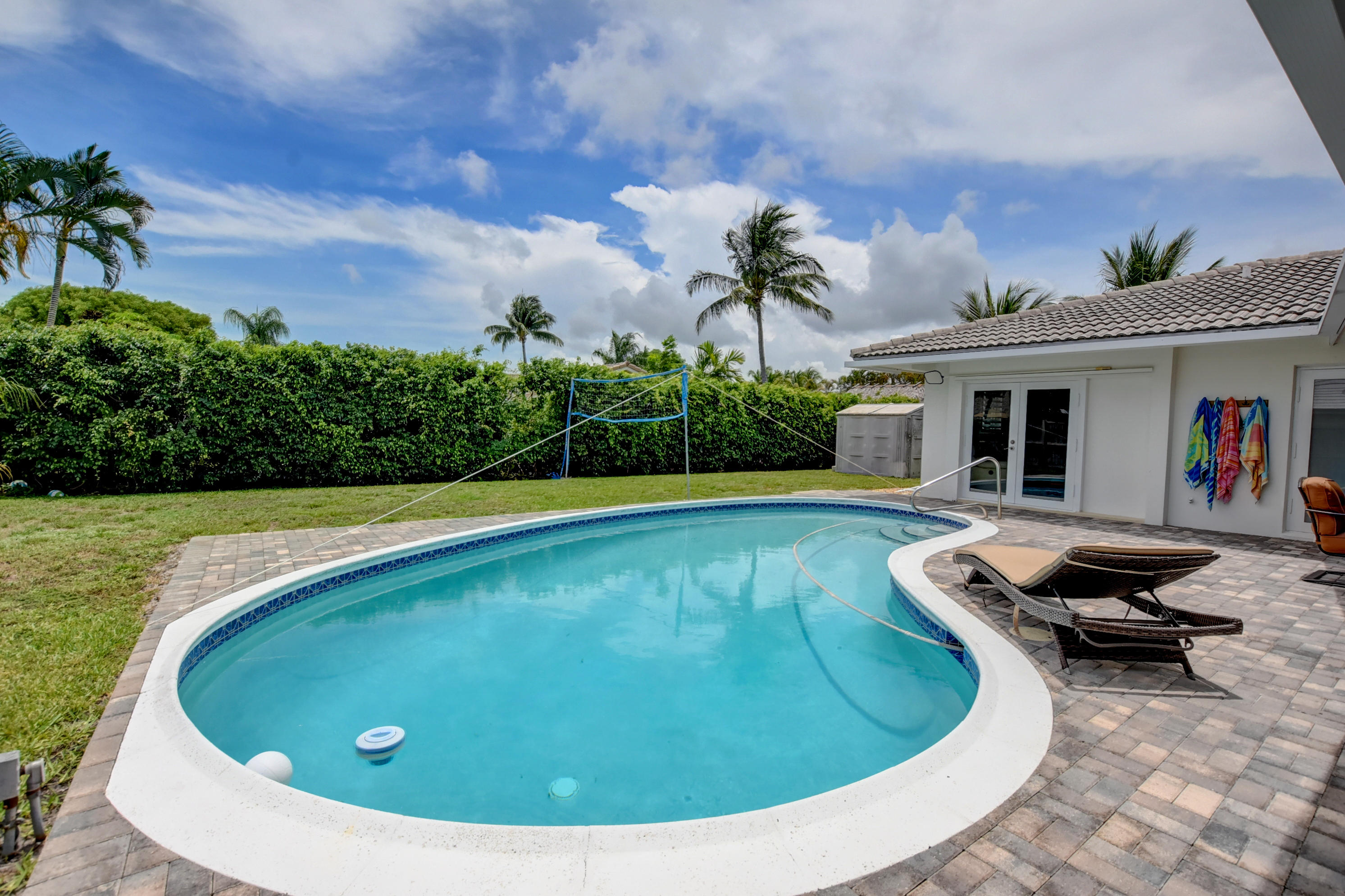1366 Southwest 13th Place Boca Raton, FL 33486 - Photo 32 of 35 a view of a swimming pool with lounge chair