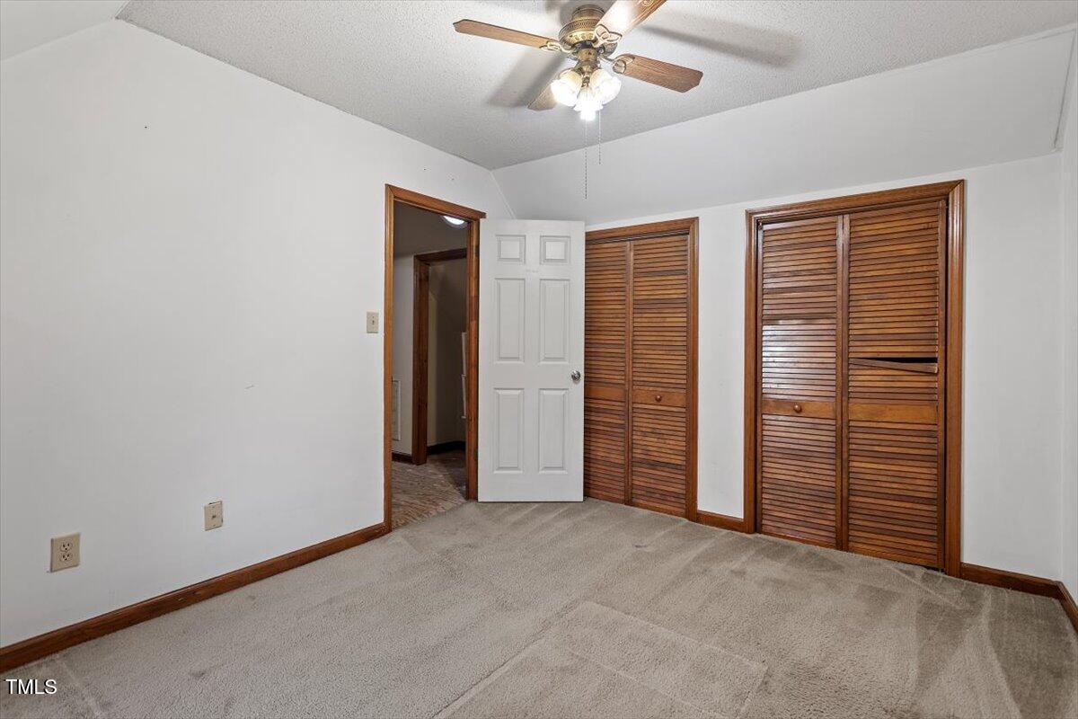 4616 Draper Road Raleigh, NC 27616 - Photo 20 of 34 an empty room with closet and a chandelier fan