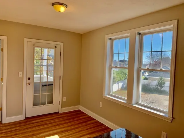 a view of a livingroom with wooden floor and windows