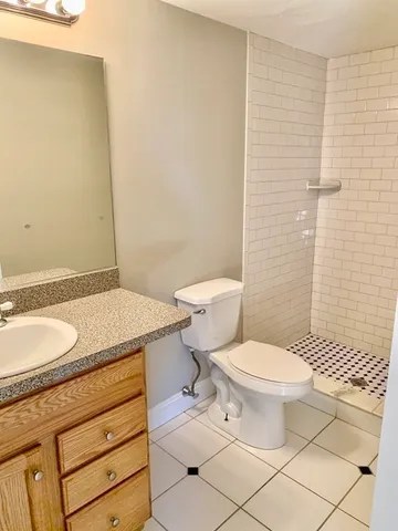 a bathroom with a granite countertop toilet and a sink