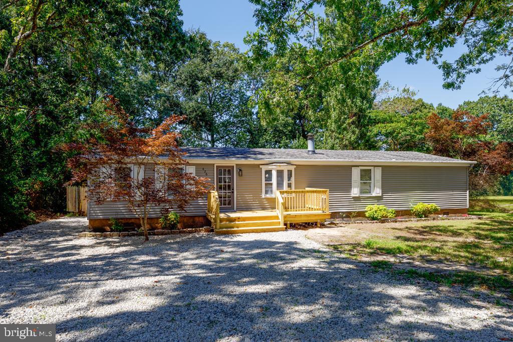 a front view of house with yard and trees in the background