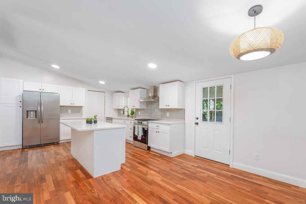 426 7th Street Somers Point, NJ 08244 - Photo 13 of 22 a kitchen with stainless steel appliances granite countertop a refrigerator a sink dishwasher a stove and white countertops with wooden floor