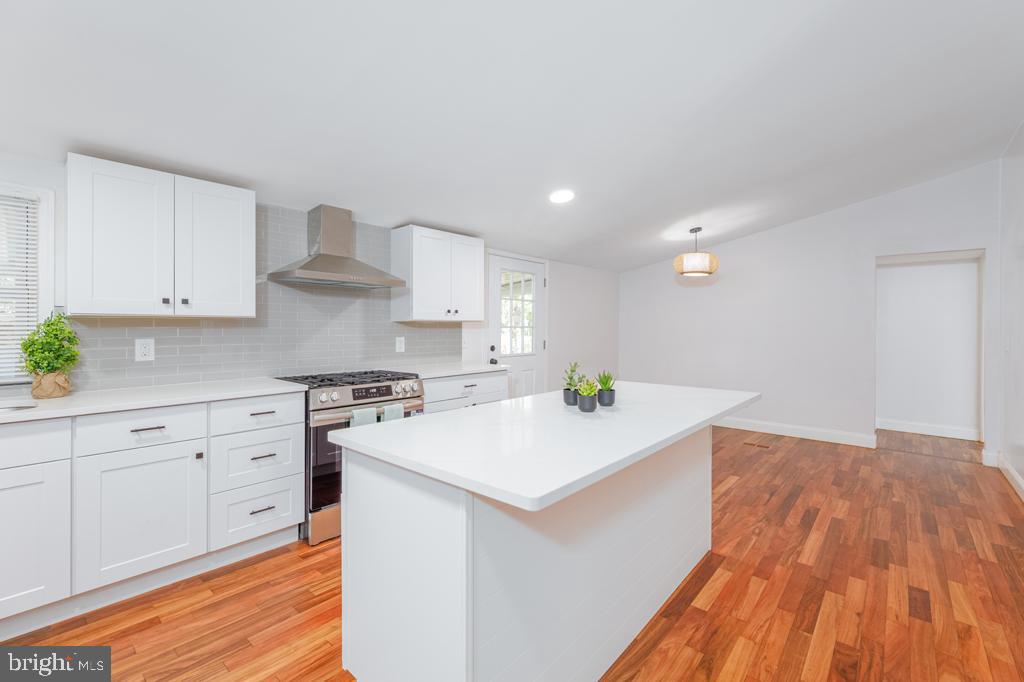 426 7th Street Somers Point, NJ 08244 - Photo 14 of 22 a kitchen with granite countertop a sink a stove cabinets and wooden floor