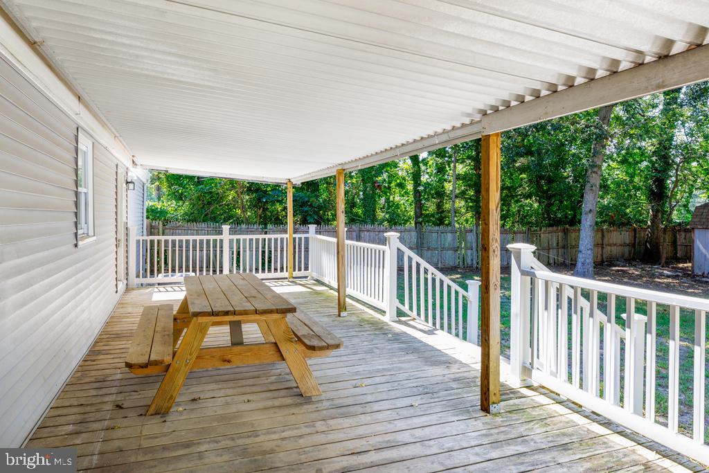 426 7th Street Somers Point, NJ 08244 - Photo 9 of 22 a view of a deck with a table and chairs next to a yard