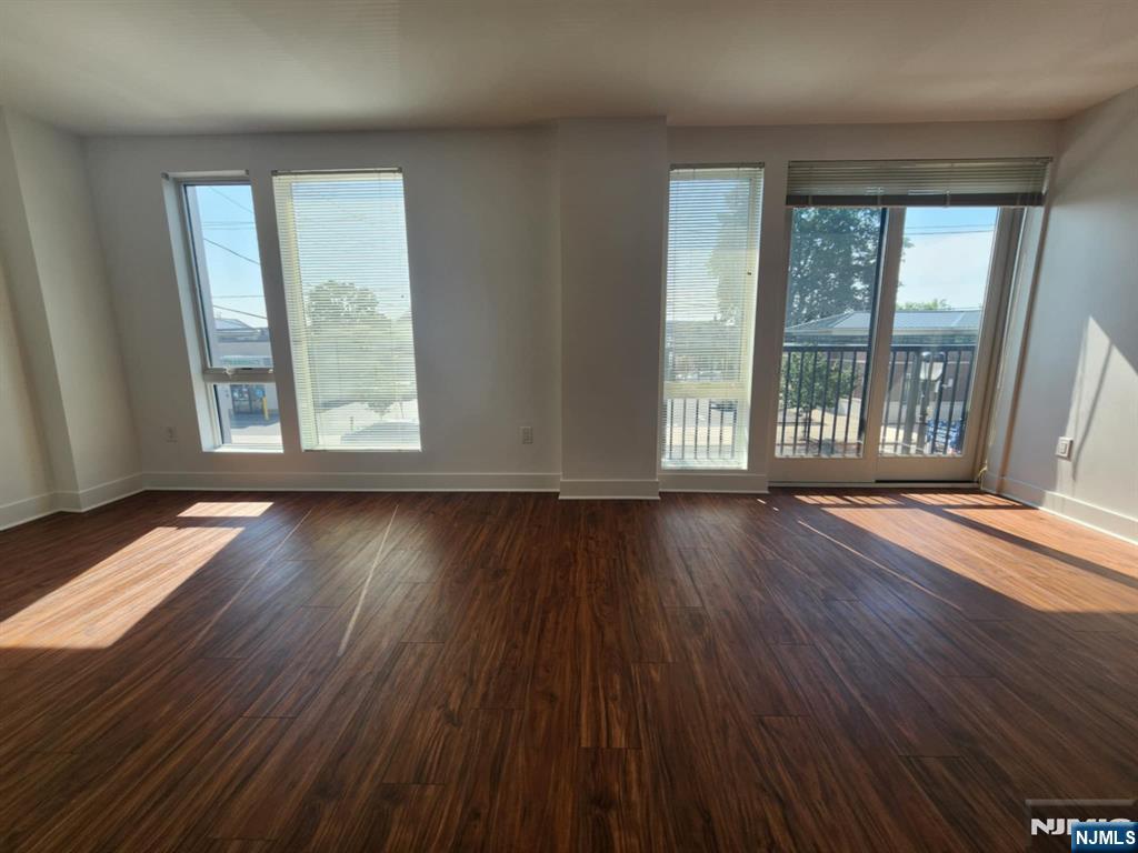 77 Ridge, Unit 108 North Arlington, NJ 07032 - Photo 11 of 24 an empty room with wooden floor and windows