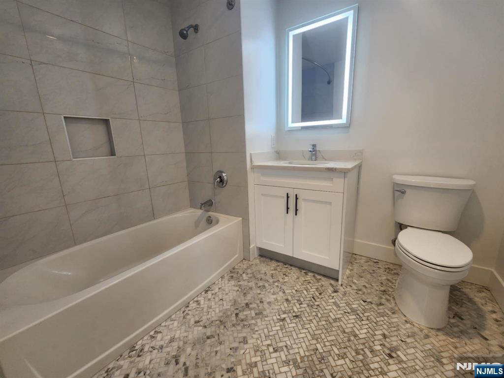 77 Ridge, Unit 108 North Arlington, NJ 07032 - Photo 13 of 24 a bathroom with a sink a toilet and bathtub