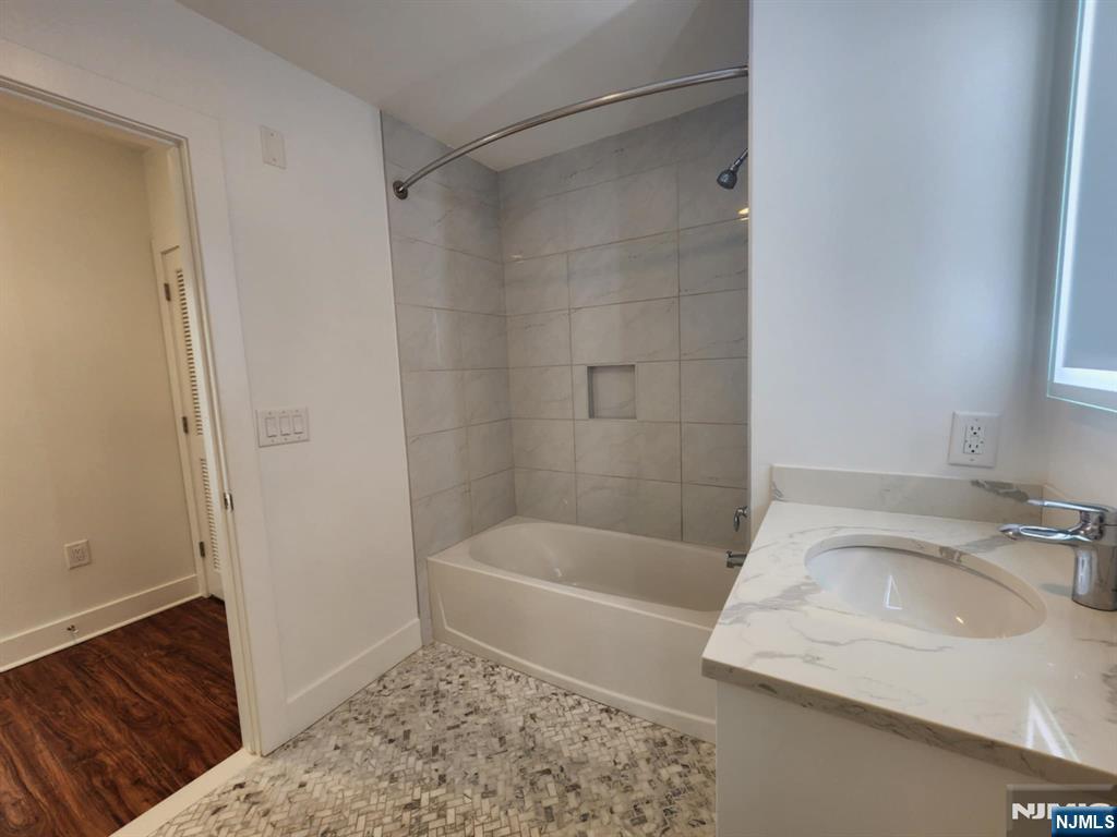 77 Ridge, Unit 108 North Arlington, NJ 07032 - Photo 14 of 24 a bathroom with a sink a bath tub and a shower