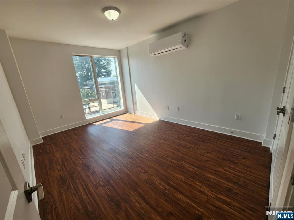 77 Ridge, Unit 108 North Arlington, NJ 07032 - Photo 15 of 24 an empty room with wooden floor and windows