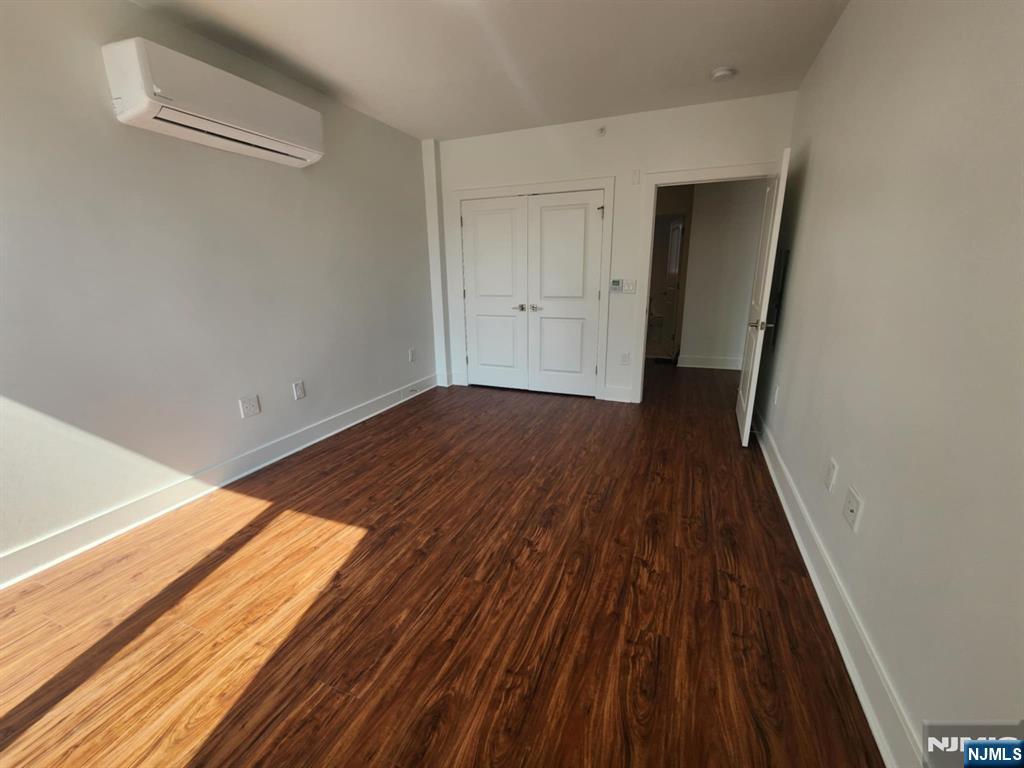 77 Ridge, Unit 108 North Arlington, NJ 07032 - Photo 16 of 24 a view of an empty room with wooden floor and a window