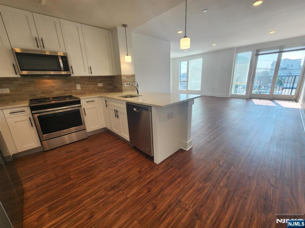 77 Ridge, Unit 108 North Arlington, NJ 07032 - Photo 4 of 24 a kitchen with wooden floors and appliances
