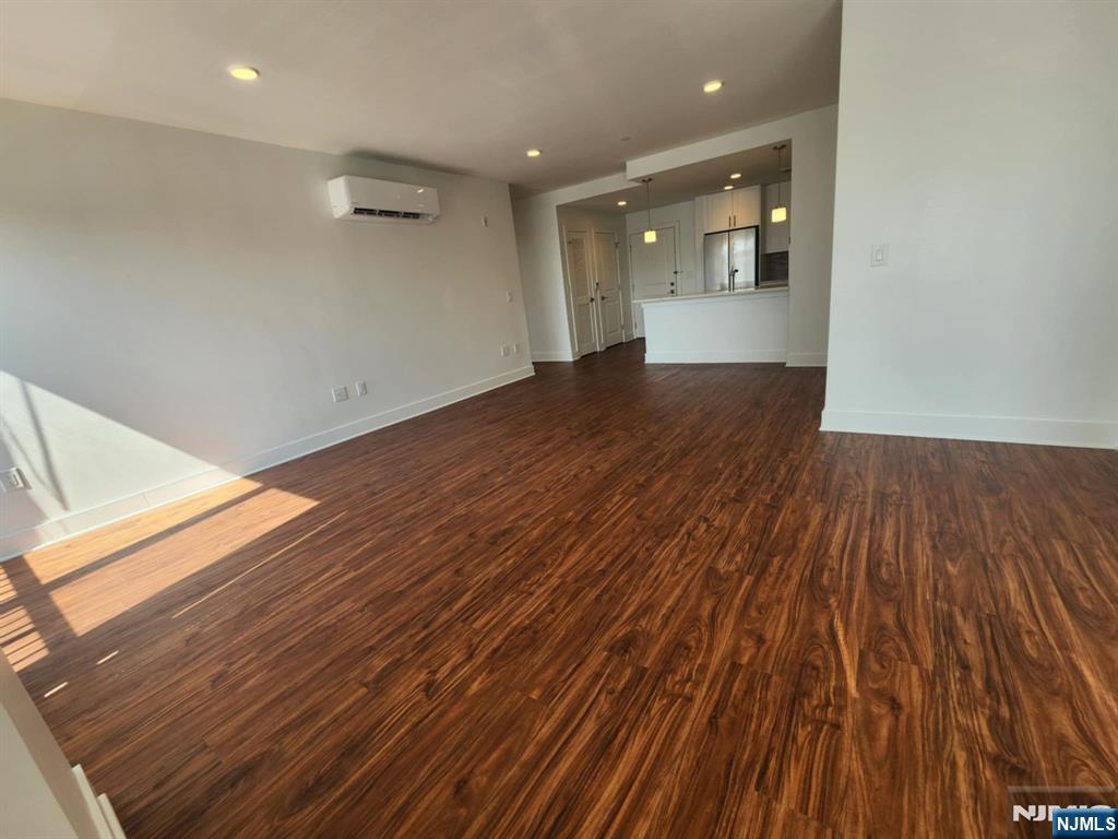 77 Ridge, Unit 108 North Arlington, NJ 07032 - Photo 10 of 24 an empty room with wooden floor and windows