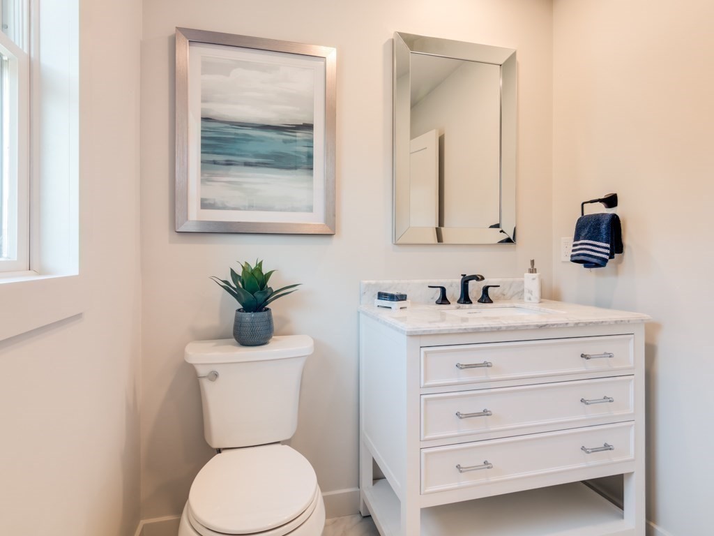 302 Western Avenue, Unit B Gloucester, MA 01930 - Photo 11 of 33 a bathroom with a toilet a sink a mirror and vanity