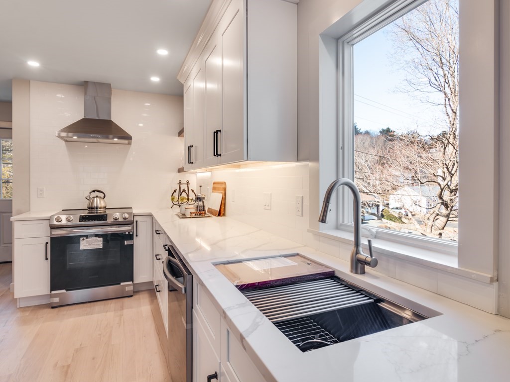 302 Western Avenue, Unit B Gloucester, MA 01930 - Photo 30 of 33 a kitchen with stainless steel appliances a stove a sink and a refrigerator