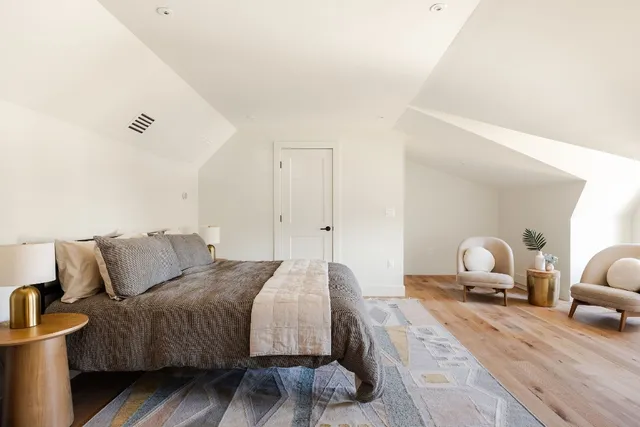 a bedroom with a bed and wooden floor