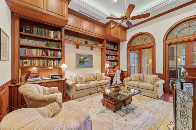 a living room with furniture a bookshelf and a large window