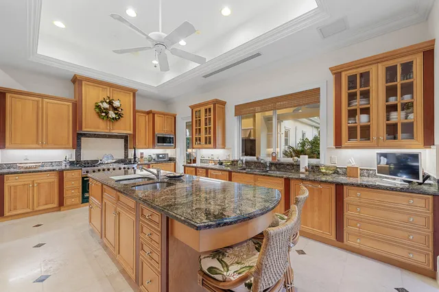 a kitchen with granite countertop a sink stove and cabinets