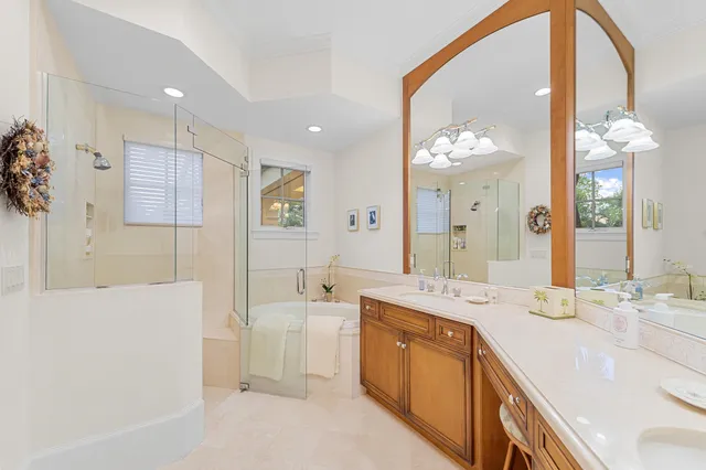 a spacious bathroom with a tub sink and mirror