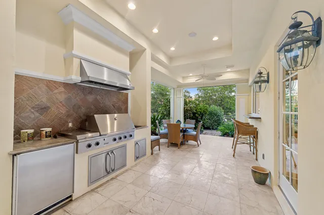 a kitchen with stainless steel appliances kitchen island granite countertop a stove a sink and a refrigerator