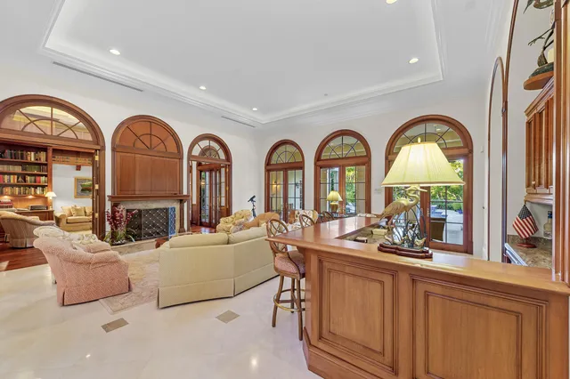 a living room with fireplace a couch and a large window