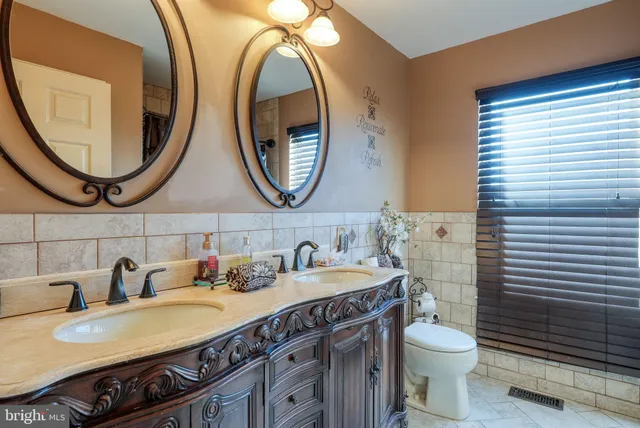 a bathroom with a granite countertop toilet a sink and a mirror