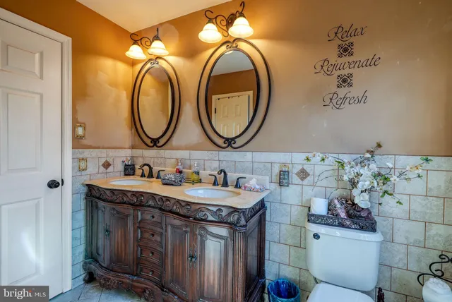 a bathroom with a granite countertop sink a toilet and a mirror