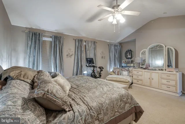 a bedroom with a bed a chandelier and dresser