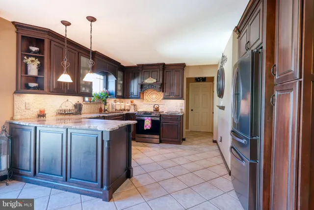 a kitchen with granite countertop a refrigerator and a sink