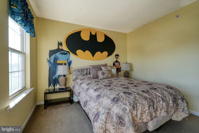 a bedroom with a bed and a painting on the wall