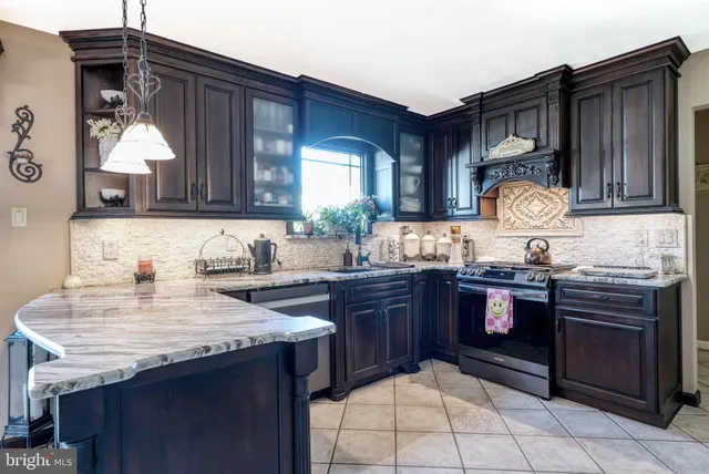 a kitchen with granite countertop stainless steel appliances a stove sink and cabinets