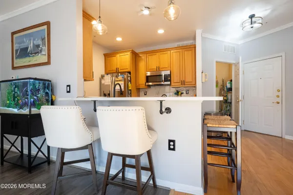 a living room with stainless steel appliances furniture a dining table and kitchen view