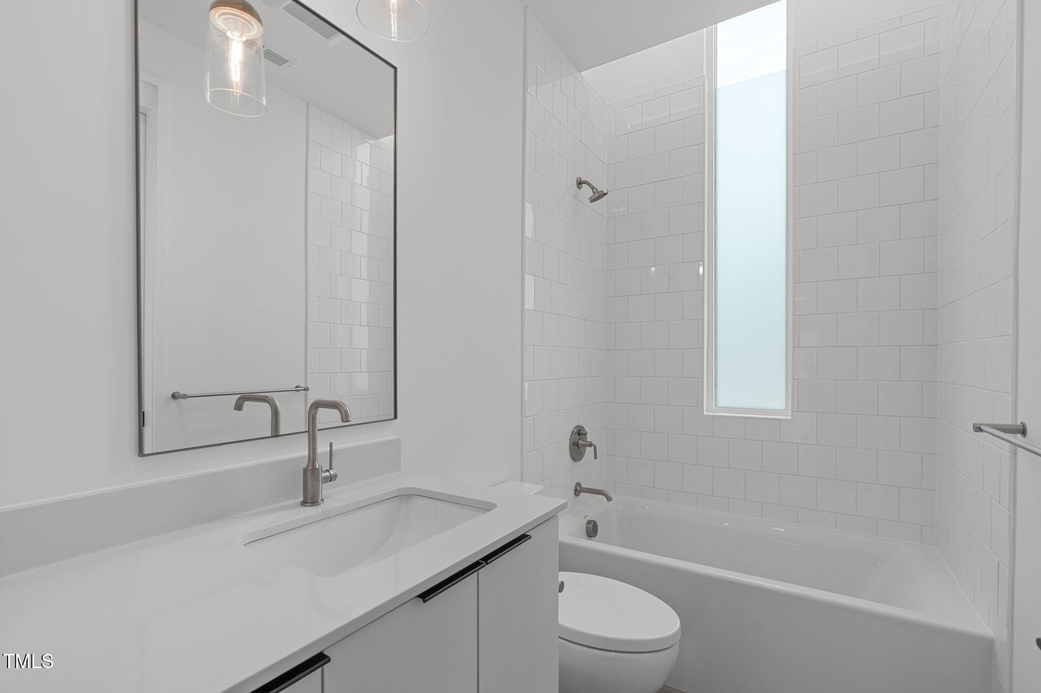 511 South Bloodworth Street, Unit 101 Raleigh, NC 27601 - Photo 21 of 51 a bathroom with a granite countertop sink a toilet and shower