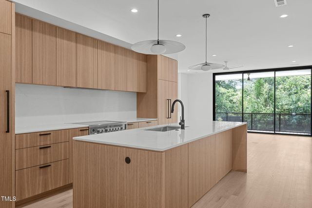 a kitchen with stainless steel appliances granite countertop a sink a stove and a refrigerator