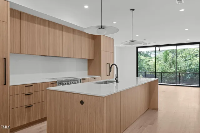 a kitchen with stainless steel appliances granite countertop a sink a stove and a refrigerator