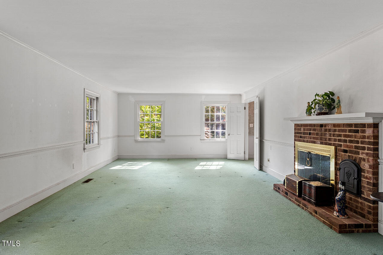 3408 Caldwell Drive Raleigh, NC 27607 - Photo 18 of 46 a view of an empty room with a fireplace and a window