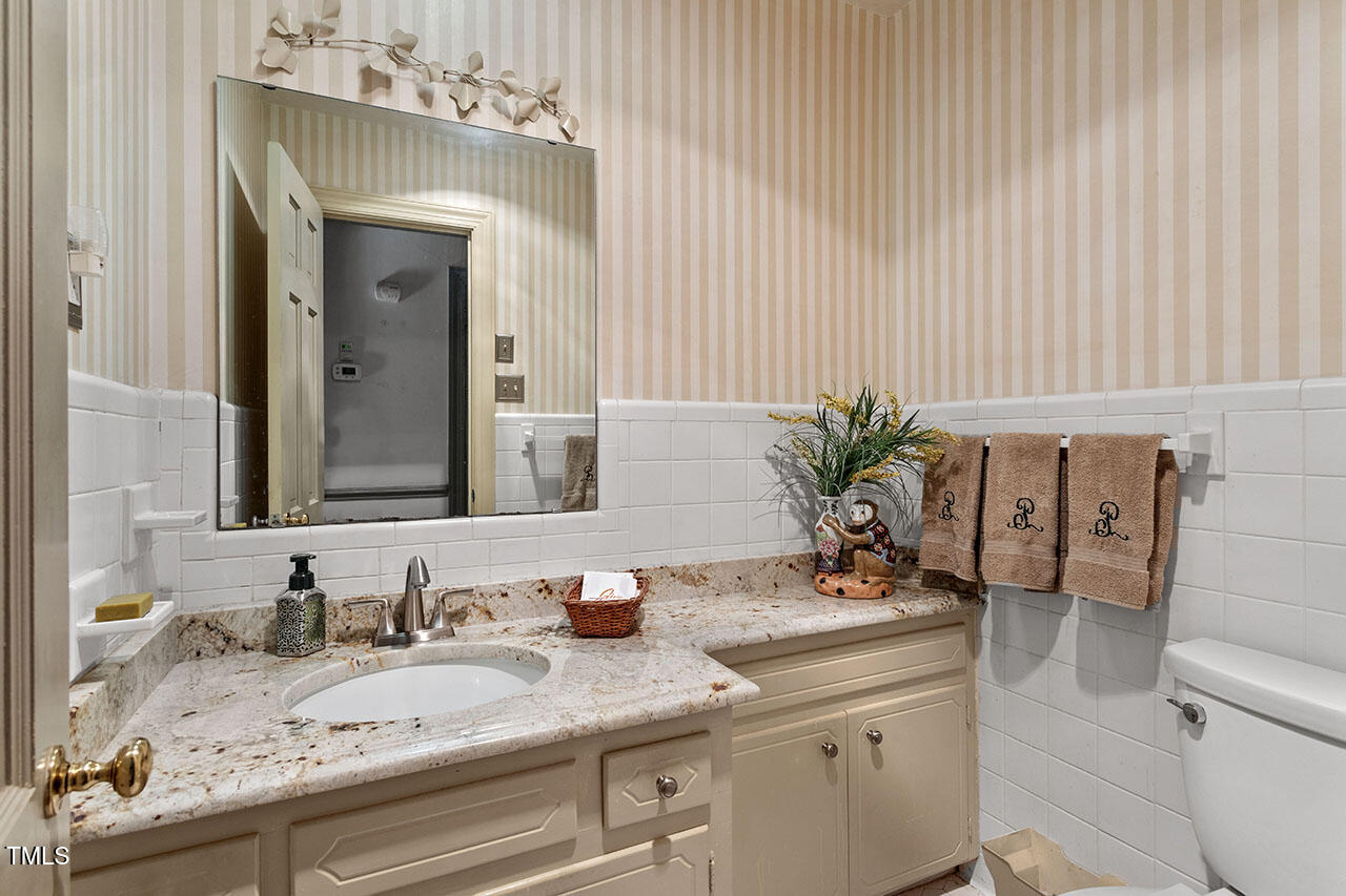 3408 Caldwell Drive Raleigh, NC 27607 - Photo 30 of 46 a bathroom with a granite countertop sink a toilet and mirror