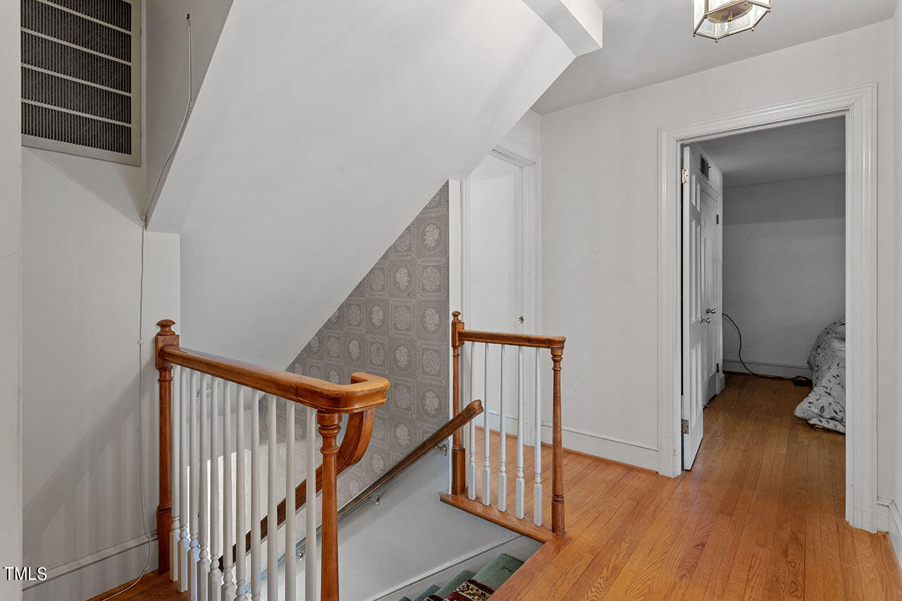 3408 Caldwell Drive Raleigh, NC 27607 - Photo 31 of 46 a view of a hallway with wooden floor and stairs