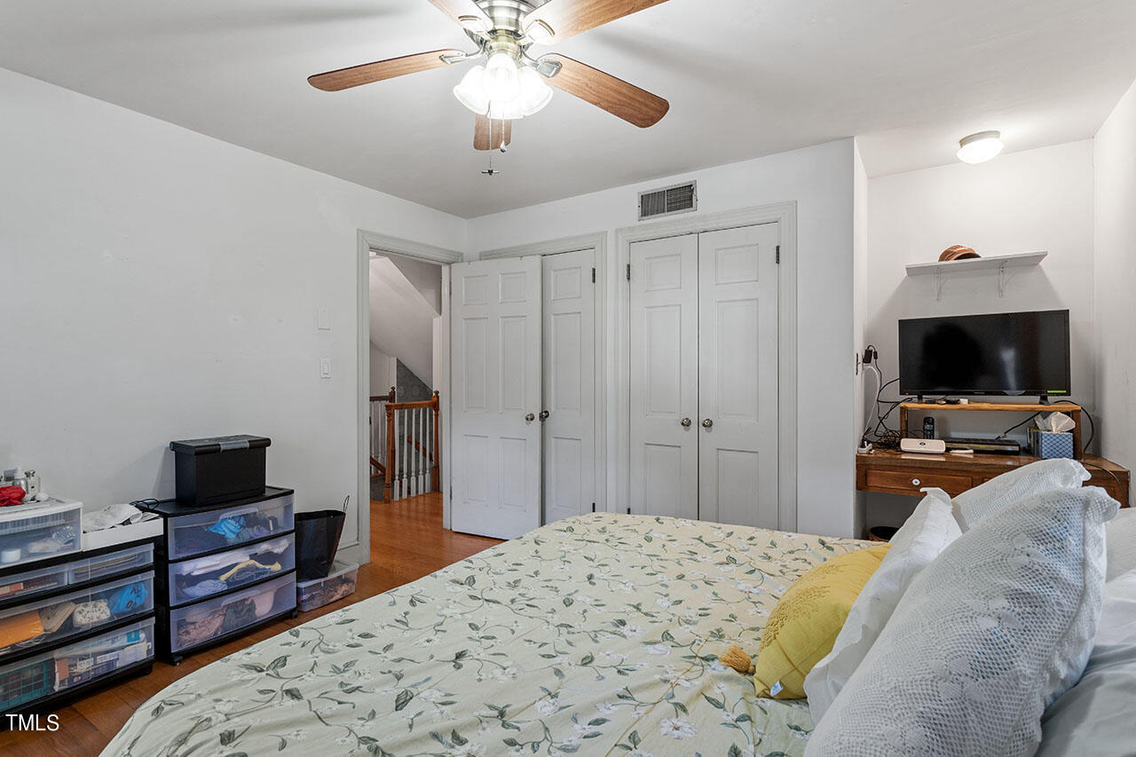 3408 Caldwell Drive Raleigh, NC 27607 - Photo 44 of 46 a bedroom with a bed and a flat tv screen on a dresser