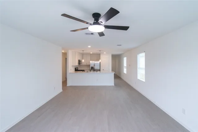 a view of a livingroom with a ceiling fan and window
